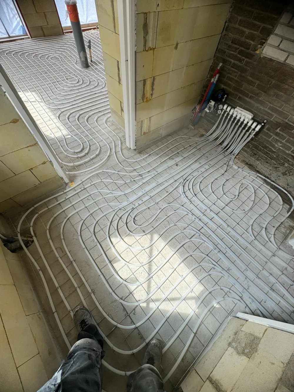 Krimpnetten vloerverwarming in corridor van nieuwbouwwoning